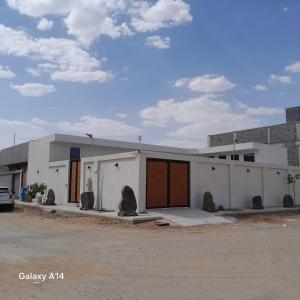 a white building with two doors on a street at شاليه ياسمين الشروق الأولى للمناسبات in Quai