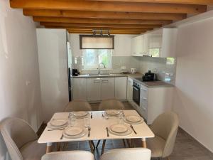eine Küche mit Tisch und Stühlen in einer Küche in der Unterkunft Stone House Bourgos in Koroni
