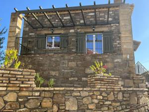a stone house with a balcony and a stone wall at Stone House Bourgos in Koroni