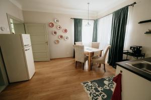a kitchen and dining room with a table and a refrigerator at Stone House in Tîrgu Secuiesc +46 photos