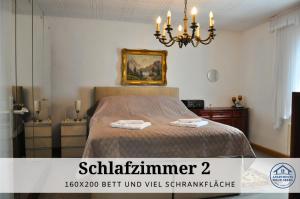 Un dormitorio con una cama y una lámpara de araña. en Apartment Rosie - Rustikal und top ausgestattet und ideal für Gruppen bis 6 Personen und Hund, egal ob Familie, Kollegen oder Freunde, 85qm mit Garten und eigener Garage, en Riegelsberg