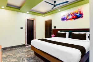 um quarto com uma cama grande e uma pintura na parede em Collection O AIIMS Kalyani em Kalyani