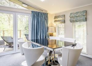 une salle à manger avec des chaises blanches et une table en verre dans l'établissement Ladera Retreat Lodges, à Eaton 38 autres photos