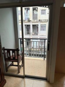 een raam met een stoel en uitzicht op een gebouw bij Kami Guest House Patong in Patong Beach