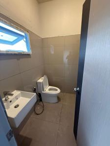 een badkamer met toilet, wastafel en raam bij Kami Guest House Patong in Patong Beach +21 foto's