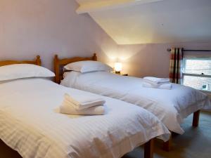 2 Betten in einem Zimmer mit weißen Handtüchern darauf in der Unterkunft Flither Cottage in Staithes + 11 Fotos