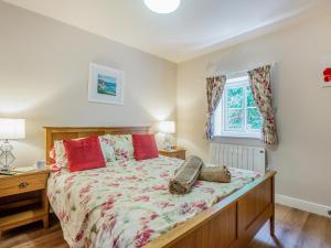 a bedroom with a large bed and a window at Bryn Awelon - Uk44122 in Moelfre