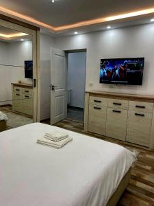 a bedroom with a white bed with a flat screen tv at Cosy Vibe 2 in Vaslui