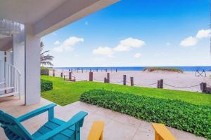 ポンパノビーチにあるBeachfront Two-Bedroom Condo with Direct Ocean Accessのビーチを望むポーチ(椅子付)