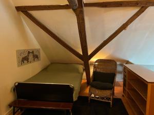 a bedroom with a bed and a chair in a attic at Vakantiewoning Fruitschuur de Morel in Venlo