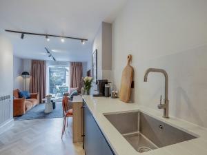 a kitchen with a sink and a living room at Restharrow - Uk49244 in Whitstable