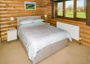 a bedroom with a bed in a log cabin at Laxfield Lodges in Laxfield