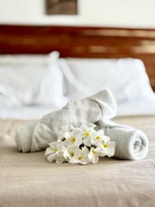 a pile of towels and flowers on a bed at Jardim Azul Praia in Pitimbu +5 photos