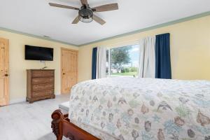 Un dormitorio con una cama con ventilador de techo y una ventana. en Manna Brach House, en Rotunda-West 40 fotos más