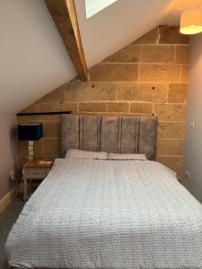 a bed in a room with a brick wall at Swallows Nest in Shrewsbury