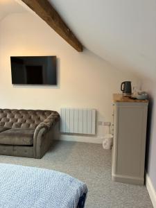 a living room with a couch and a flat screen tv at Swallows Nest in Shrewsbury