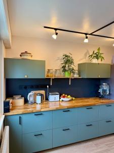 a kitchen with blue cabinets and a wooden counter top at The Mandala Room in Thionville
