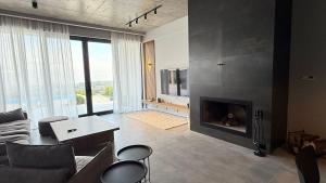 een woonkamer met een bank en een open haard bij Luxury Villa #1 in Stantsiya Mukhiani
