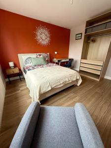 a bedroom with a bed and a red wall at The Mandala Room in Thionville