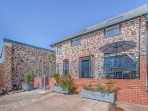 a brick building with an umbrella in front of it at The Stables - Uk49089 in Crediton