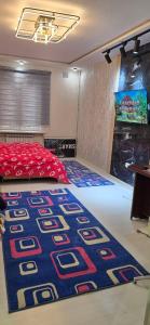 タシュケントにあるCHORSU komplex Hazrati Imamの青と赤のカーペットが敷かれたベッドのある寝室