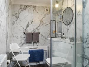 a bathroom with a shower and a toilet and a sink at Coast To Coast Cottage in Cleator Moor +4 photos