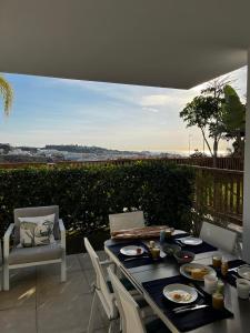 einen Tisch und Stühle auf einer Terrasse mit Aussicht in der Unterkunft Mijas Tres Caminos in La Cala de Mijas