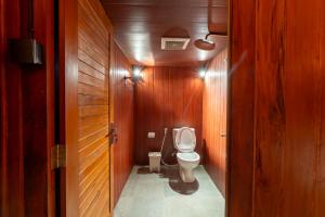 La salle de bains est pourvue de toilettes dans un couloir en bois. dans l'établissement Lumbung Serinity Villa - Adis Villa, à Sukawati