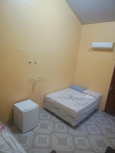 a small bedroom with a bed and a trash can at Suites para casais com area nativa in Manacapuru +1 photo