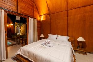une chambre avec un lit avec un animal en peluche dessus dans l'établissement Lumbung Serinity Villa - Adis Villa, à Sukawati
