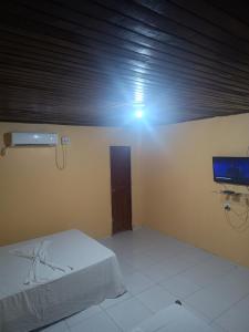 a room with a bed and a tv on the wall at Suites para casais com area nativa in Manacapuru