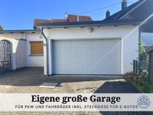 una puerta de garaje blanca al lado de una casa en Apartment Rosie - Rustikal und top ausgestattet und ideal für Gruppen bis 6 Personen und Hund, egal ob Familie, Kollegen oder Freunde, 85qm mit Garten und eigener Garage, en Riegelsberg