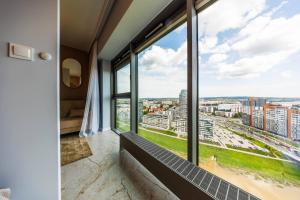 a room with large windows with a view of a city at OLSZYNKI PARK 2- High-End Luxury Apartment with View, City Centre by StayNest in Rzeszów
