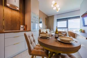 a kitchen and dining room with a wooden table and chairs at OLSZYNKI PARK 2- High-End Luxury Apartment with View, City Centre by StayNest in Rzeszów