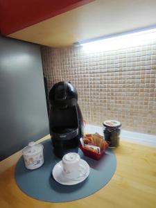 a coffee maker sitting on a table with cups on it at Leo House in Trezzo sullʼAdda +14 photos