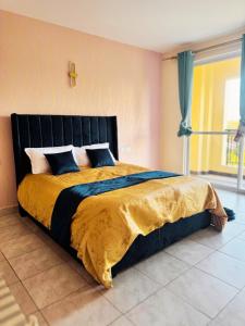 1 dormitorio con 1 cama grande con una cruz en la pared en Sunshine Home, en Nanyuki 8 fotos más