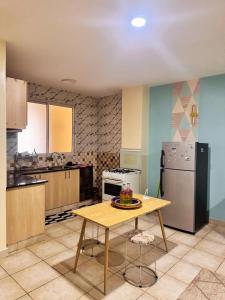 una cocina con una mesa y un refrigerador en Sunshine Home, en Nanyuki