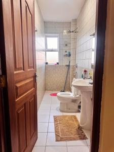 a bathroom with a toilet and a sink at Sunshine Home in Nanyuki +8 photos
