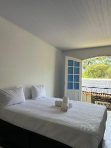 Un dormitorio con una cama con una toalla encima. en San Sebastian Taipu de Fora, en Maraú