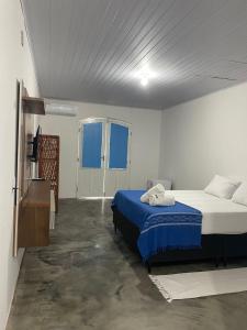 Un dormitorio con una cama y un televisor. en San Sebastian Taipu de Fora, en Maraú