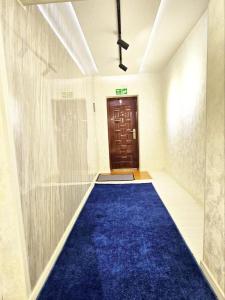タシュケントにあるCHORSU komplex Hazrati Imamの青いカーペットとドアのある廊下