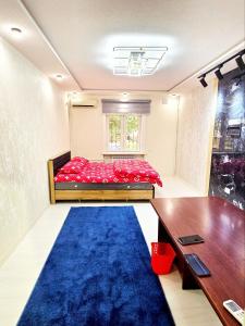 タシュケントにあるCHORSU komplex Hazrati Imamの赤いベッドと青いカーペットのある寝室
