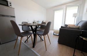 a dining room table and chairs in a living room at Sarananda - apartment in Saint-Valery-sur-Somme