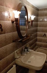 a bathroom with a sink and a mirror on the wall at Anatoli's Apartment in Artemida
