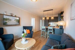 a living room with blue couches and a table at Campingland Ostsee in Schashagen