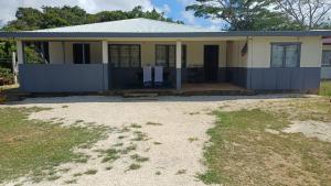 a home with a blue and white house at Tongan Homestay in Neiafu