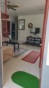 a living room with a green rug on the floor at Tongan Homestay in Neiafu