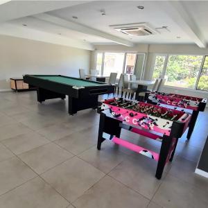 a room with a pool table and some chairs at Suite Rincon del Sol in Pinamar