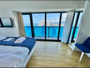 a bedroom with a bed and a view of the ocean at ORBI CITY Black Sea LUXURY hotel in Batumi