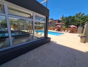 a house with glass windows and a swimming pool at Suite Rincon del Sol in Pinamar